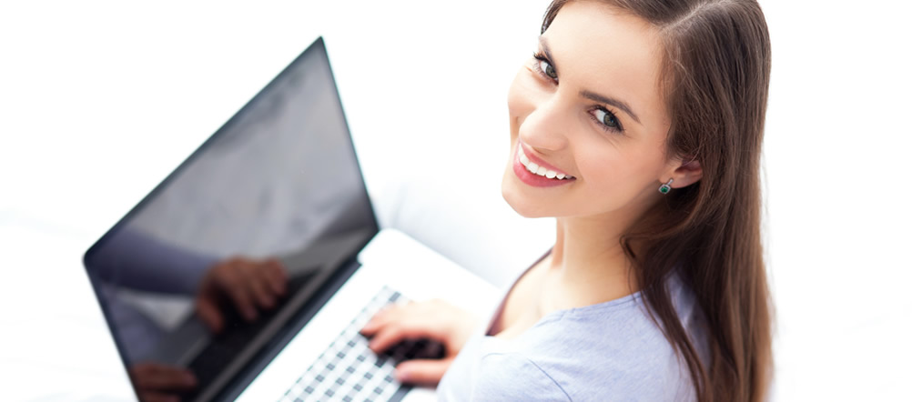 a young lady is holding an open laptop and smiling